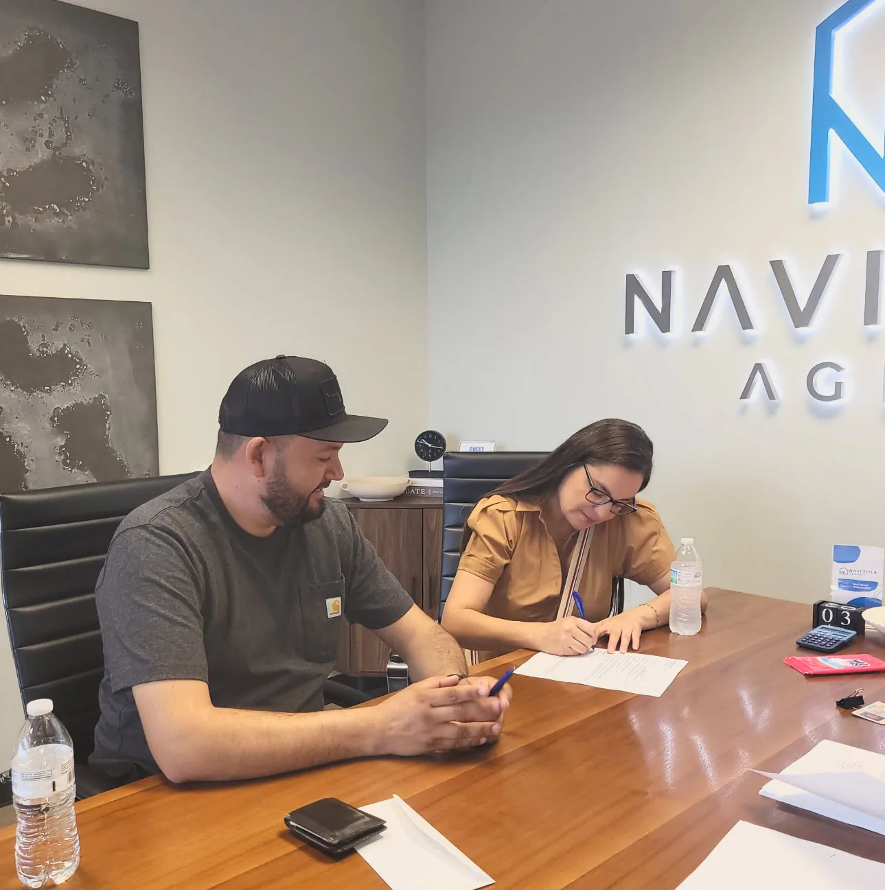 A couple signing their closing paperwork at the title agency.